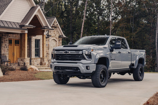 Black Widow Silverado HD in driveway in front of house with light  brown brick